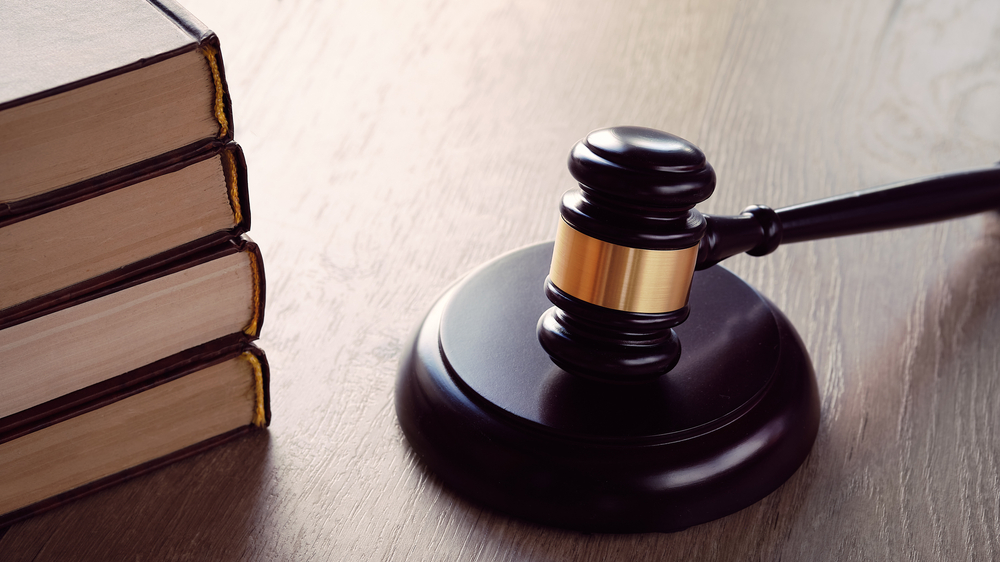 Image of a gavel next to a pile of legal books