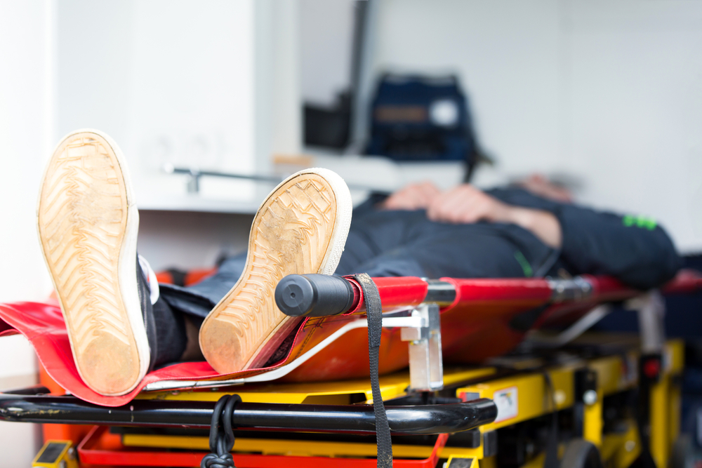 Photograph of man on a stretcher inside an ambulance 