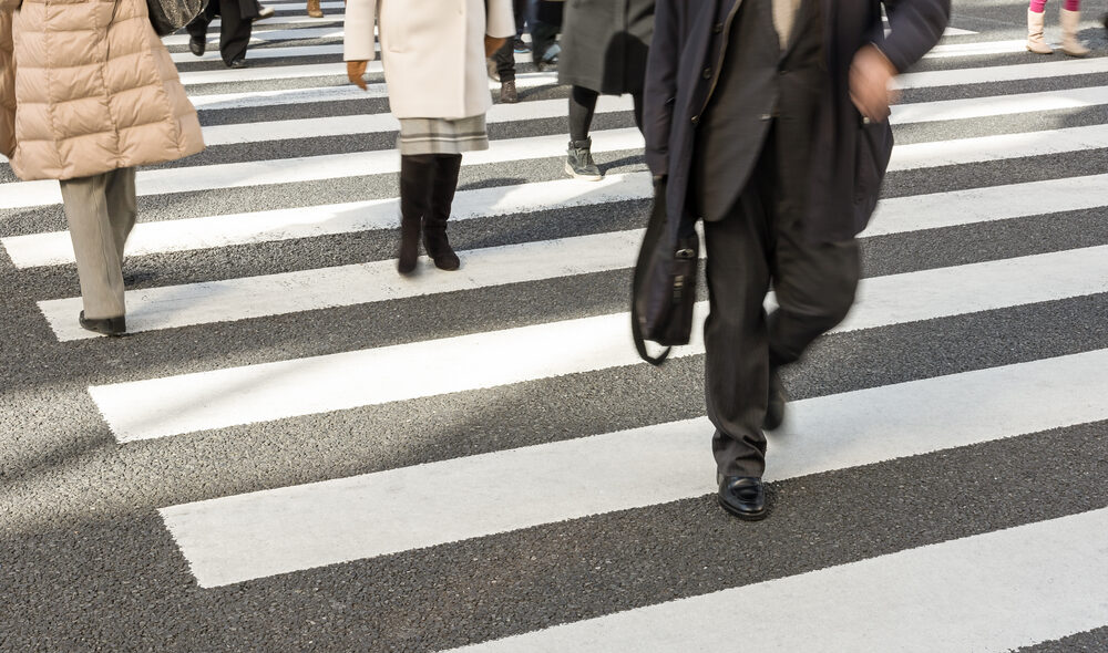 Group of busy people in suits crossing the road
