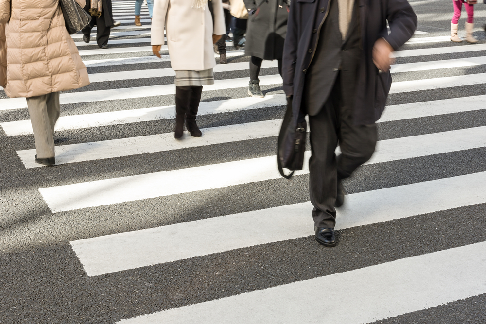 Group of busy people in suits crossing the road