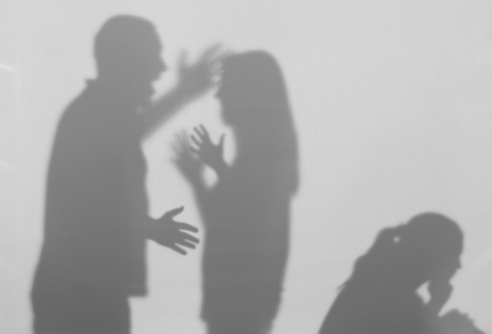 Silhouettes of quarreling parents and little child on white background