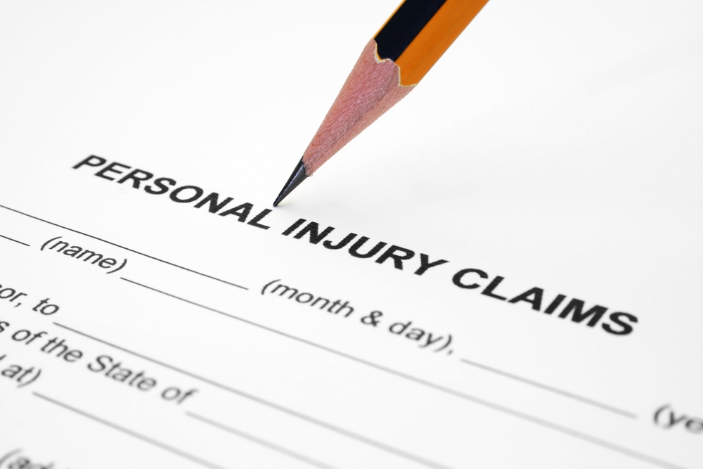 Personal Injury Claim Form with a pencil pressing down on the top of the page