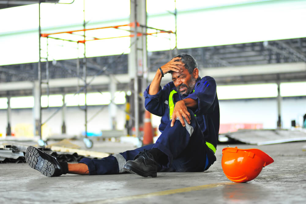 Man in construction who is on the floor after an accident at work