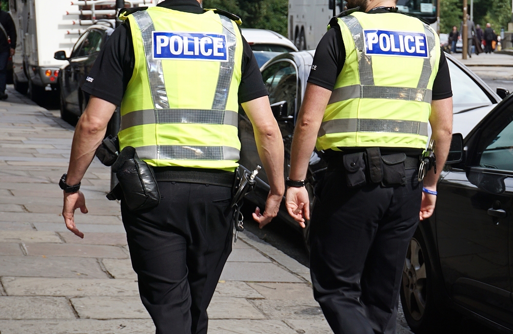 Two police officers on duty walking down high street in high vis jackets