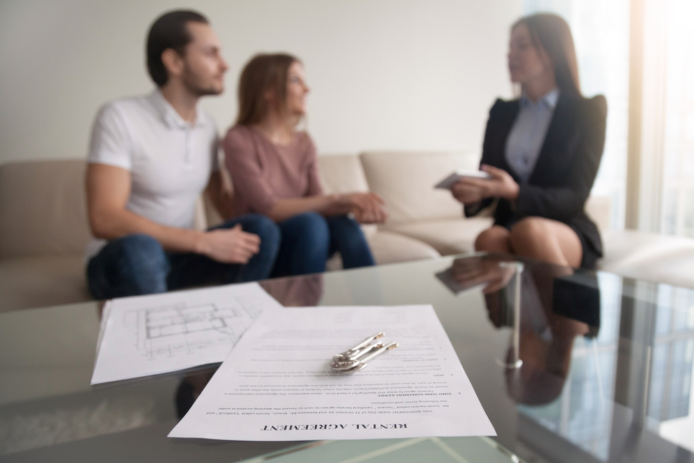 Solicitor papers in the foreground with a blurred background of a solicitor talking to a couple about their claim options