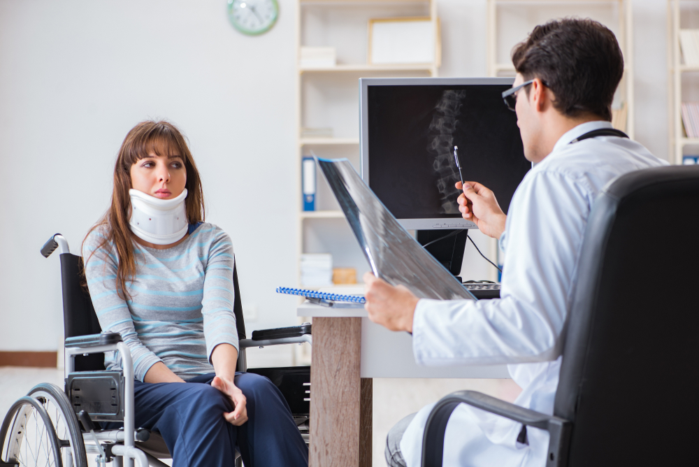Young woman in a neckbrace and wheelchair visiting doctor after loss of earning accident