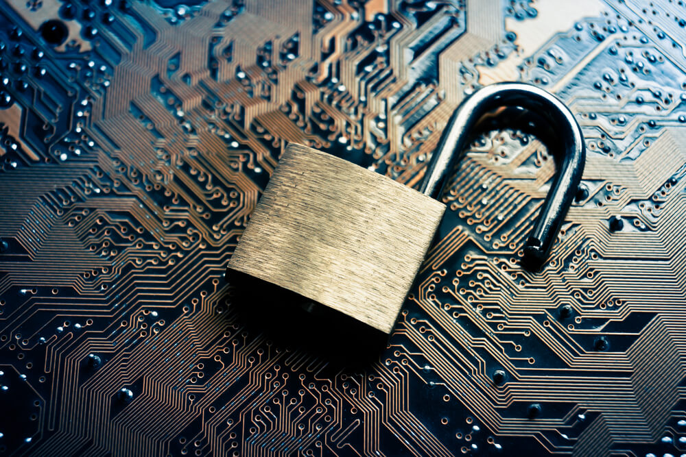 Image of an unlocked padlock resting on a computer circuit board to represent a business data breach