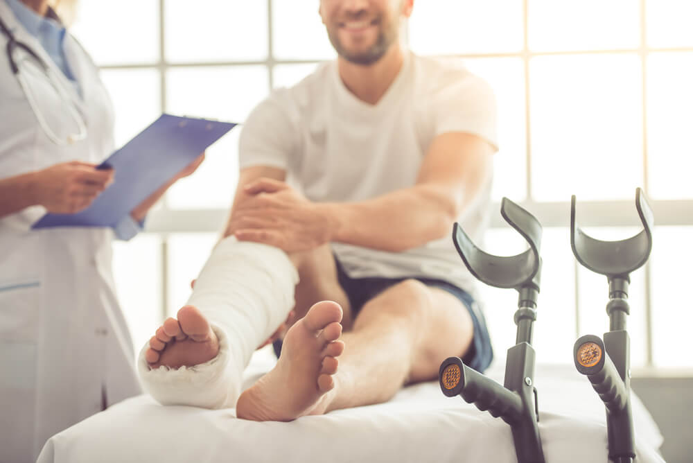 Man involved in loss of earning accident with a broken leg, talking to his assigned doctor