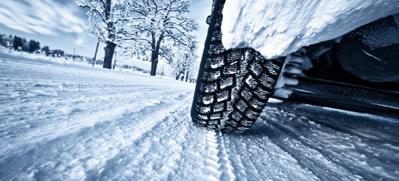 Car tyre driving through thick snow
