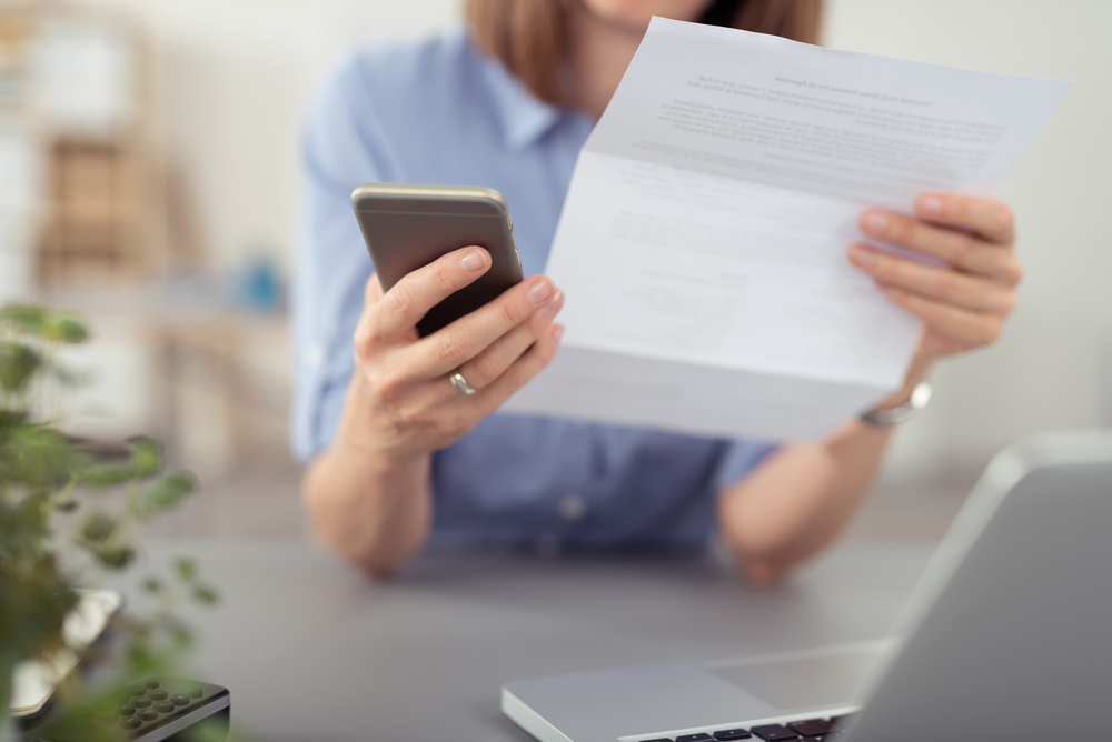 Woman paying outstanding debt after receiving a bailiff enforcement letter