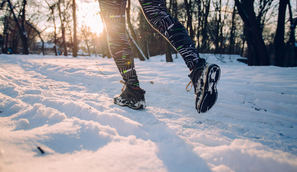 Photograph of young woman jogging in snow