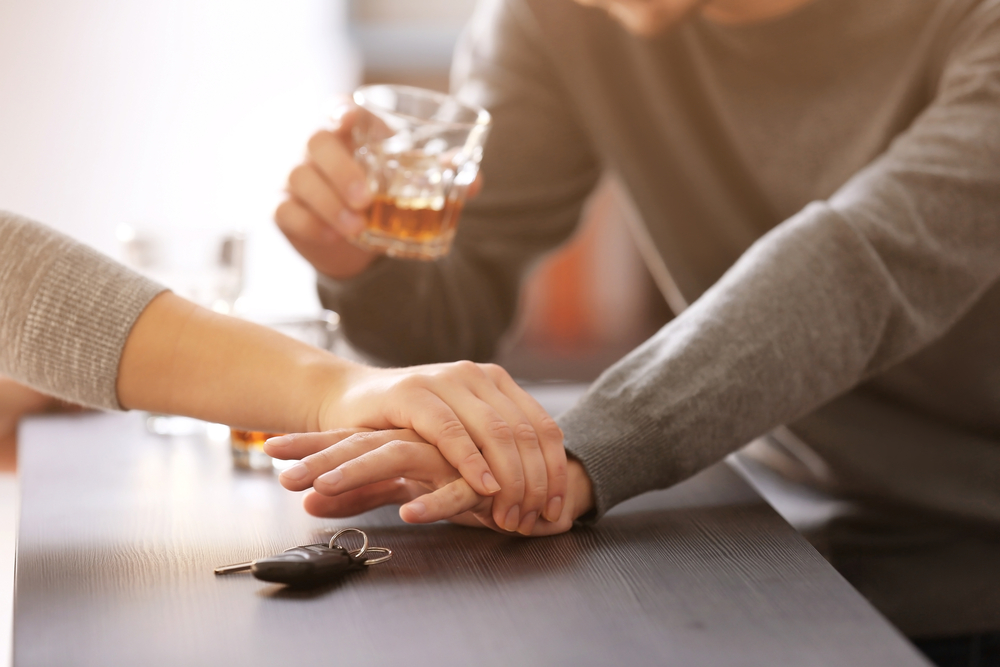 Female bartender preventing male customer from drinking and driving by taking away car keys