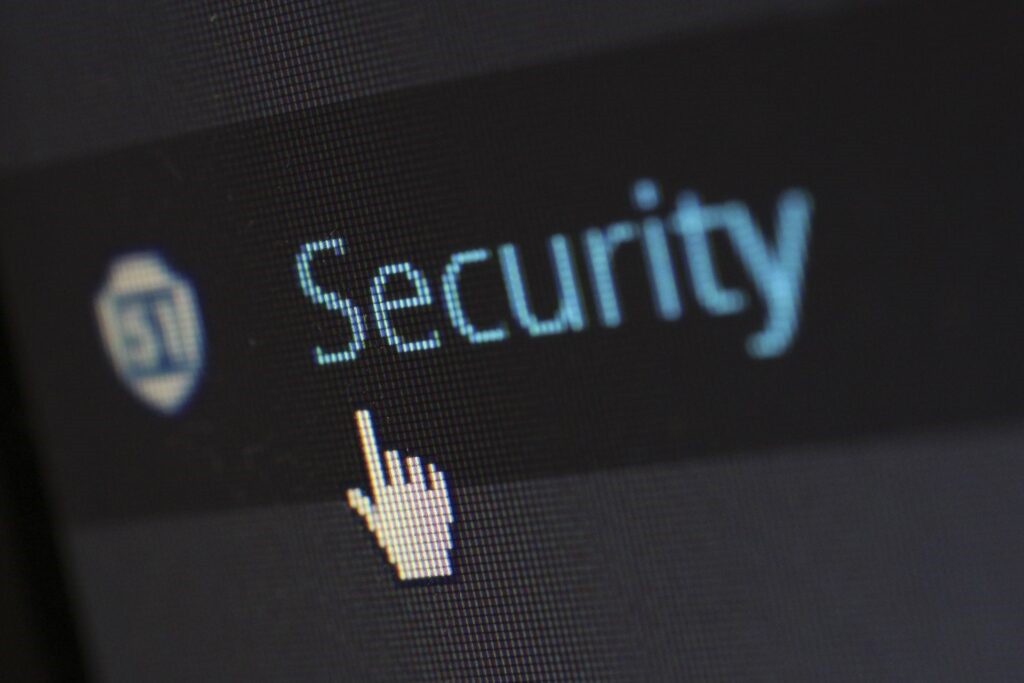 Zoomed in image of computer screen with the cursor on the word Security written in blue against a black background