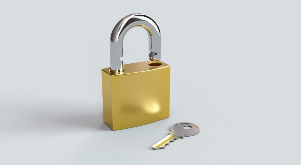 A gold padlock with a key next to it on a white background.