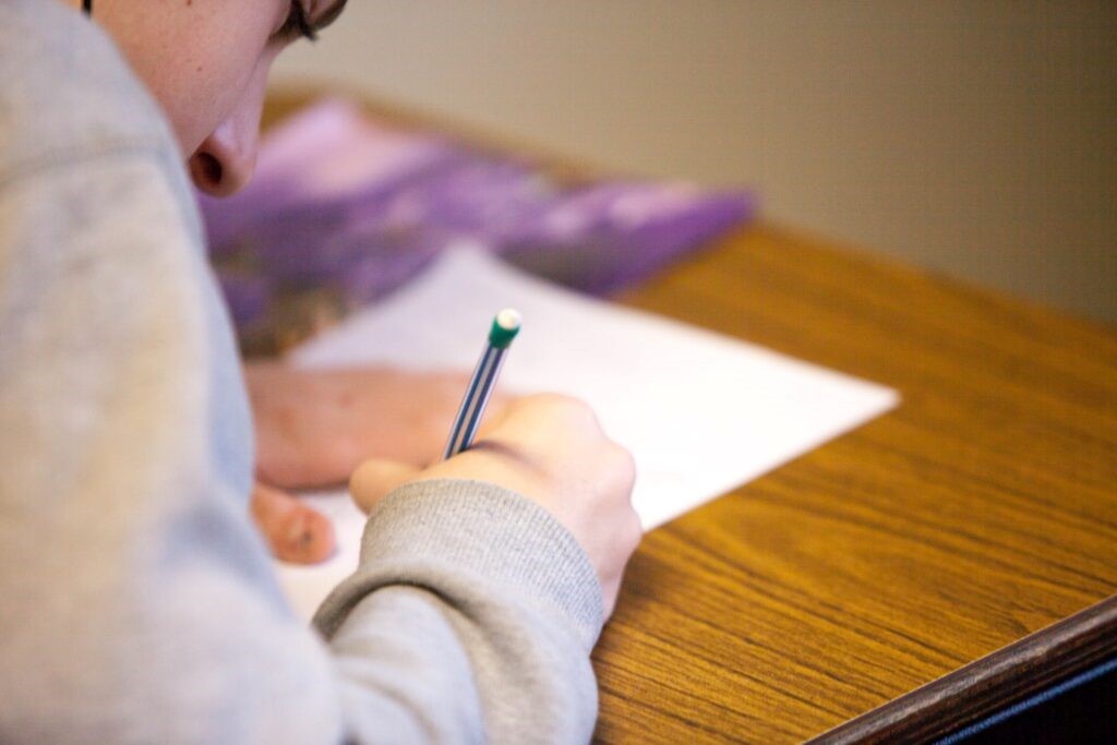 A person writing on a piece of paper understanding what is victim support. 