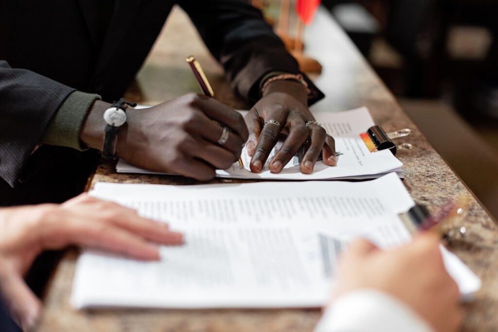 A person's hand signing papers