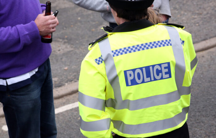 British police officer stops member of public.