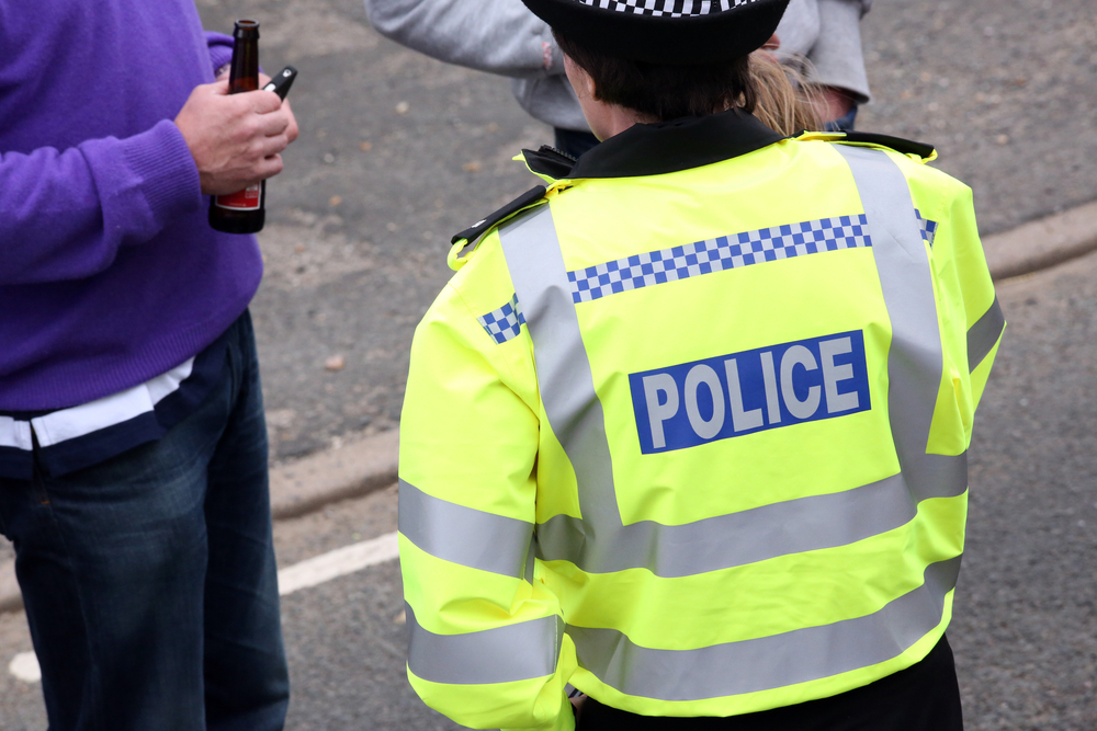 British police officer stops member of public.