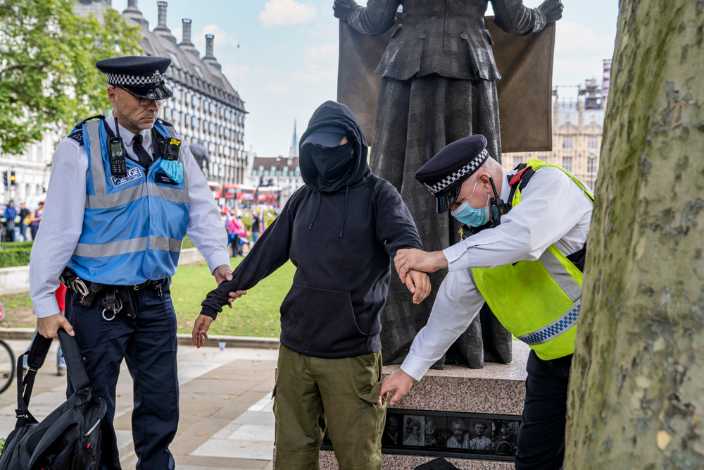 Man wearing black hoody and green shorts is searched by police officer and PCSO for actions against the police case study.