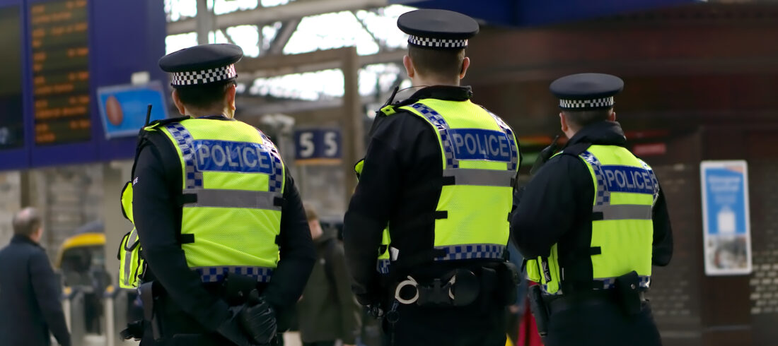 UK police stand surveying train station for blog about compensation for damage caused by police.