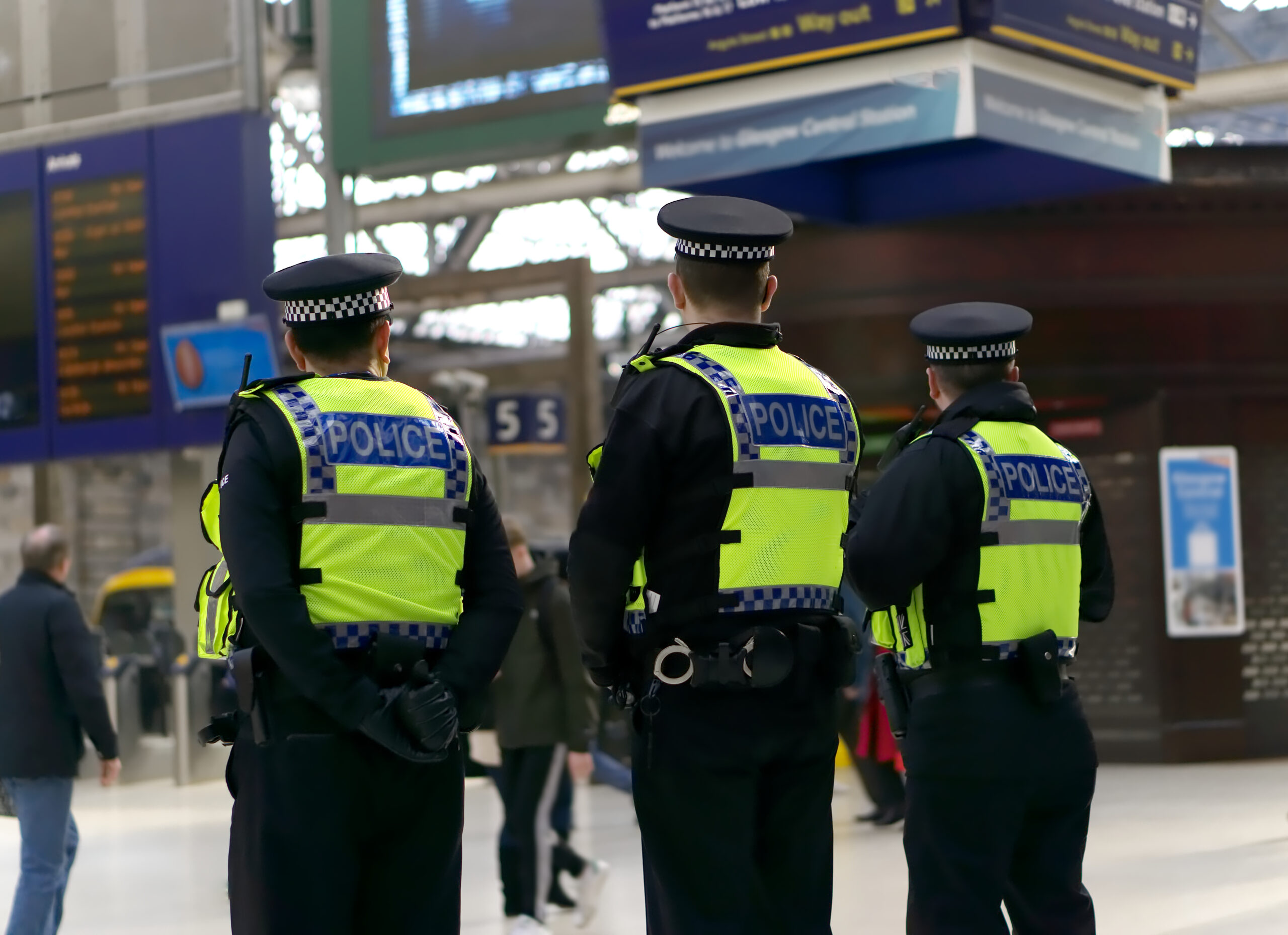 UK police stand surveying train station for blog about compensation for damage caused by police.