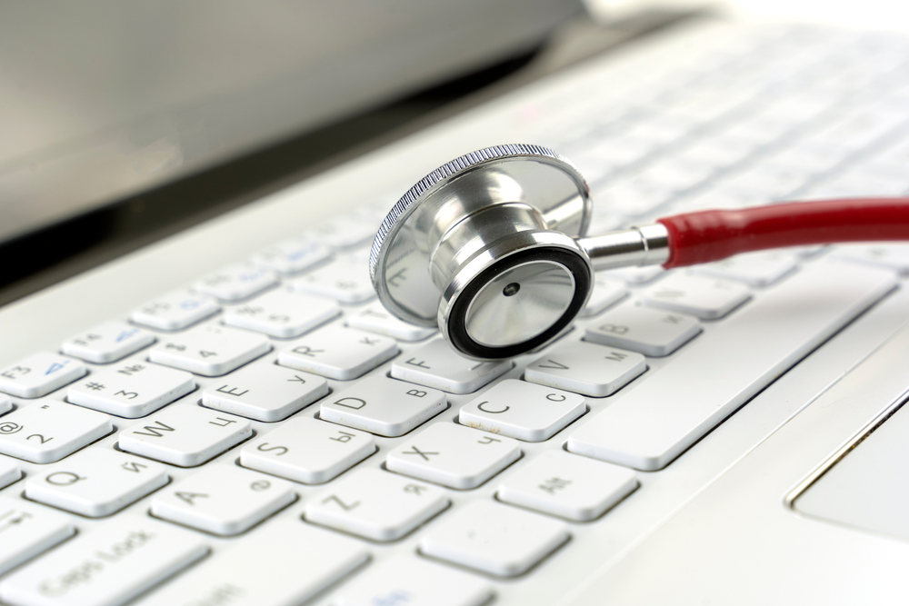 medical data breach concept image, a stethoscope lying on a laptop keyboard
