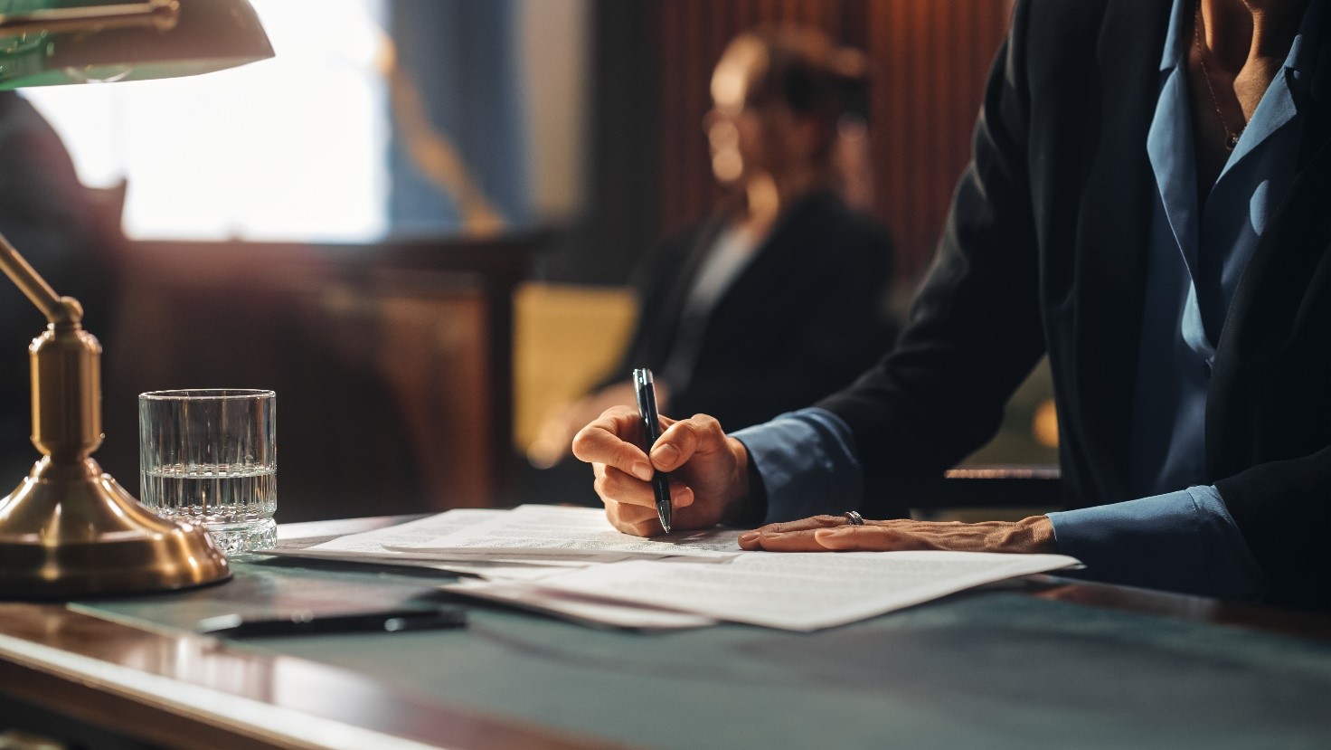 Image of a solicitor sat at a desk making notes on a piece of paper