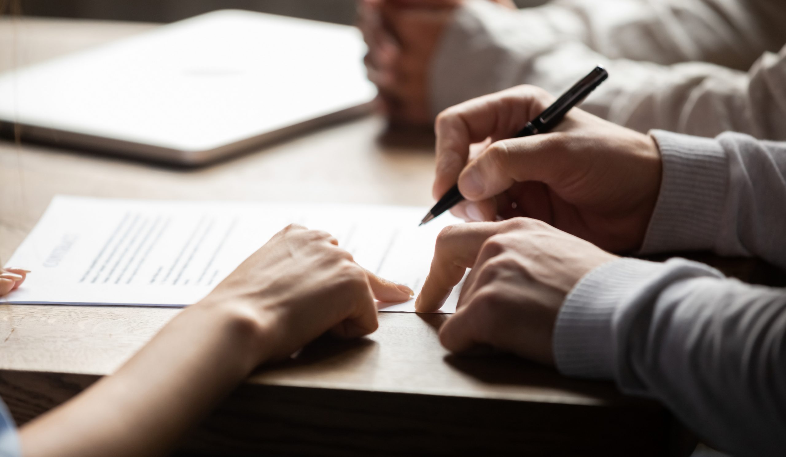 Solicitor pointing at insurance contract showing male client where to write signature sign sale purchase employment agreement at meeting make financial business deal, bank loan service, close up view