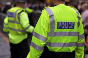 Image of the back of two police officers policing a crowded street 