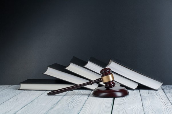 An image of a gavel in front of a pile of books