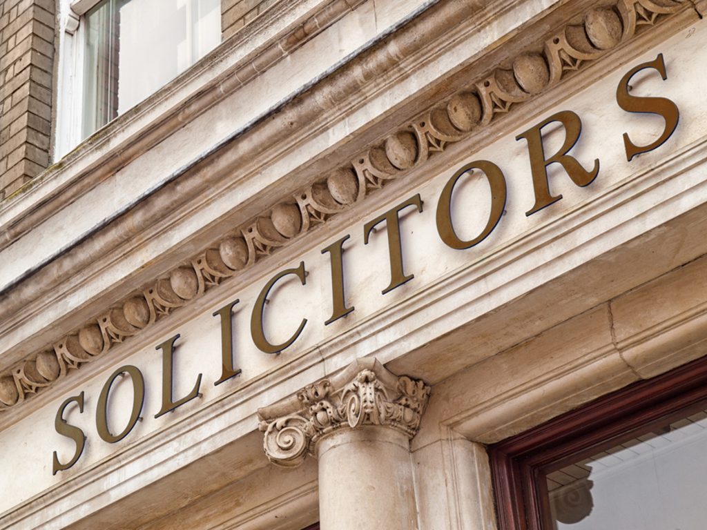 A close up image of a Solicitors sign on top of a building 