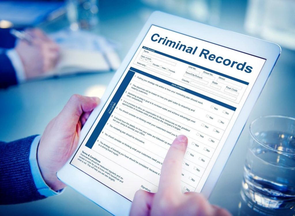 Image of someone filling in a criminal records form on a tablet.