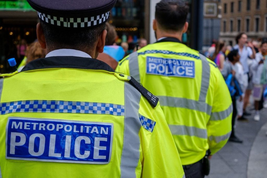 Image of the back of two Metropolitan police officers on a busy street