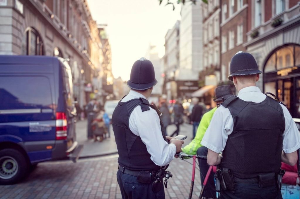 Image of two police officers talking to a man on the street 