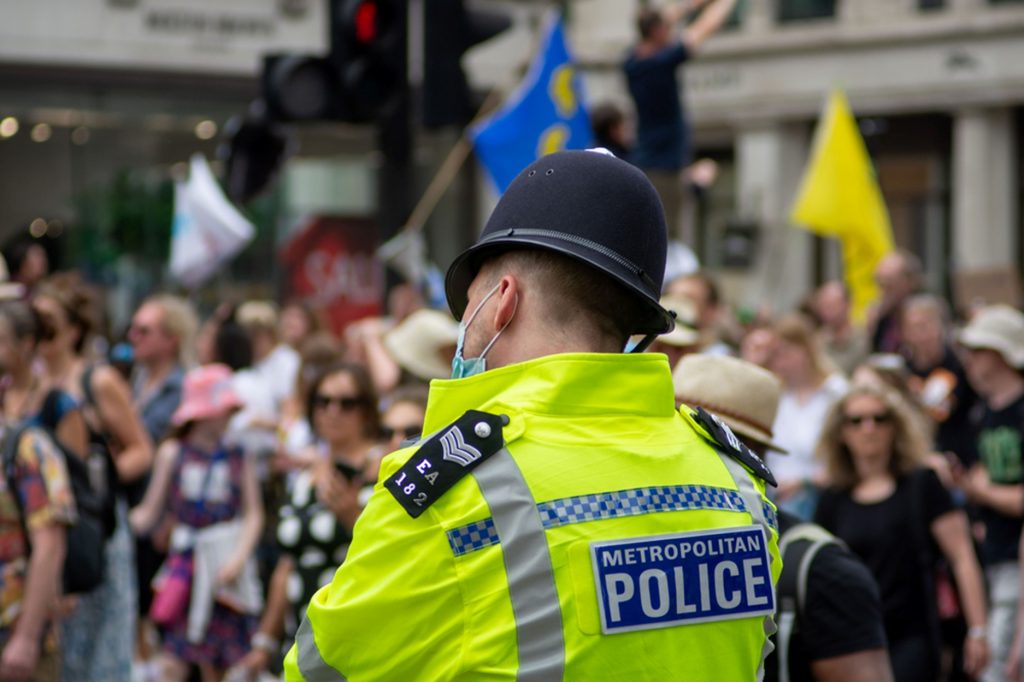 Picture of a Metropolitan police officer with a mask on policing a protest 