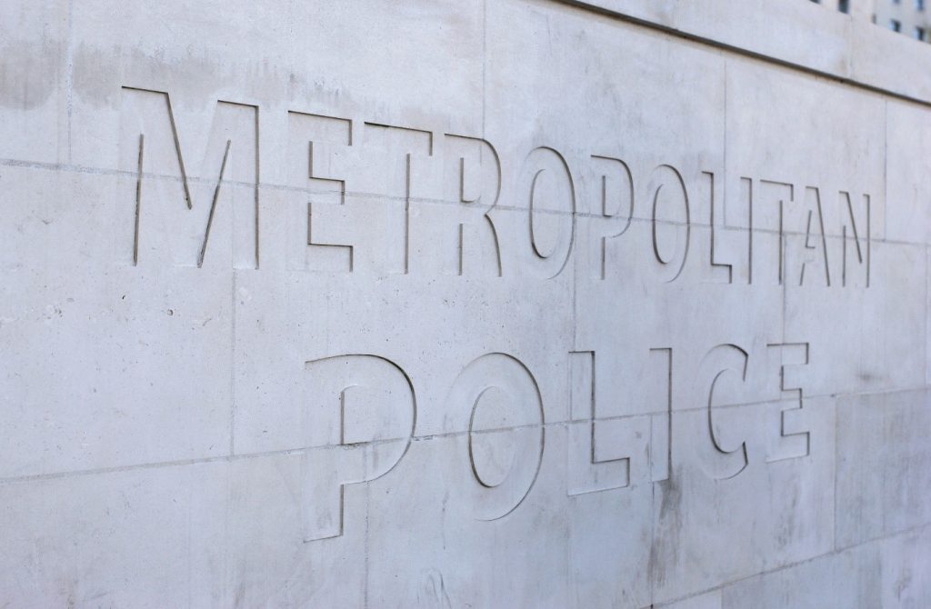 A picture of the words Metropolitan Police carved into a stone wall. 