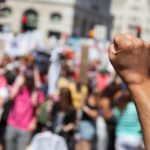 A raised fist of a protestor at a political demonstration