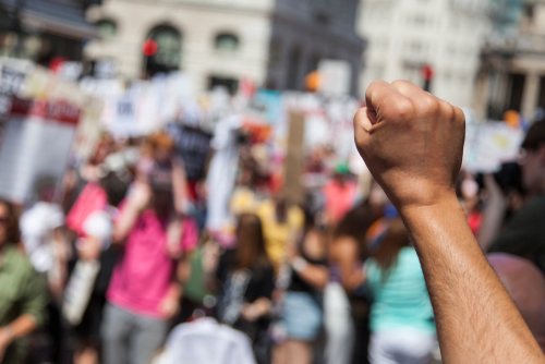 A raised fist of a protestor at a political demonstration