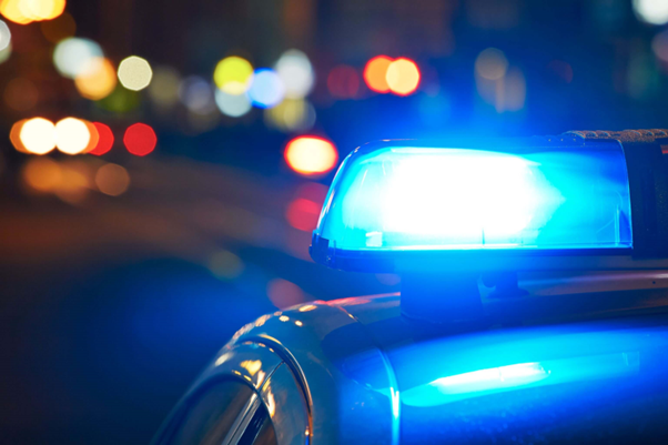 Close up picture of a police car blue light lit up at night