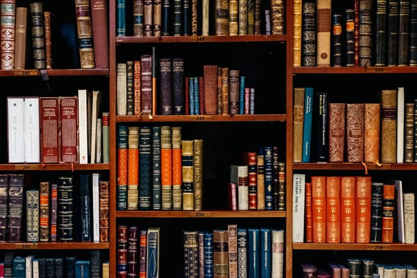 A picture of wooden bookshelves in a library full of old books.