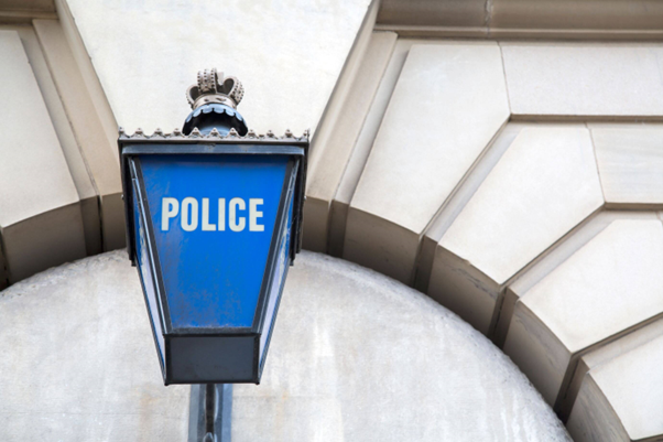 A picture of a blue police light above a police station.