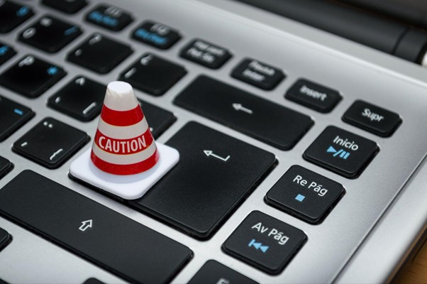 An image of tiny caution cone sat on top of a keyboard.