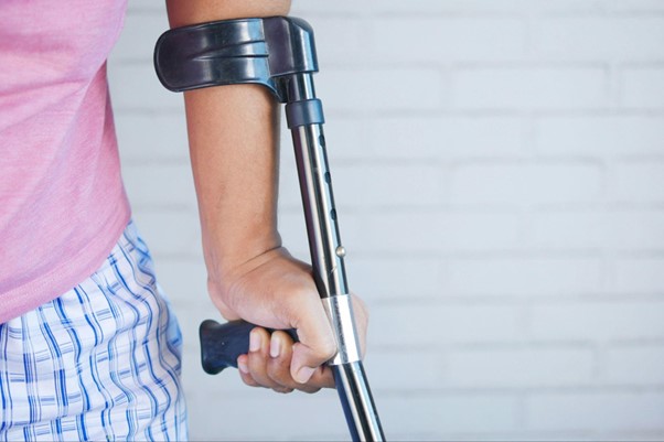 A picture of a man using a crutch. 