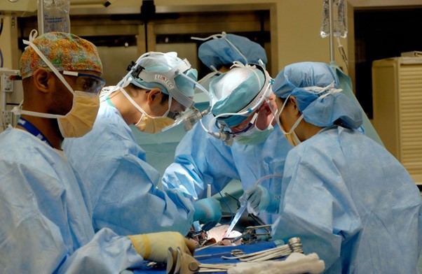 A picture of surgeons and nurses conducting surgery on a patient.