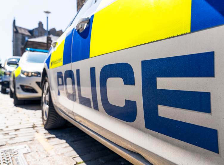 An up close picture of the side of a police car with the word POLICE written in blue across the bottom