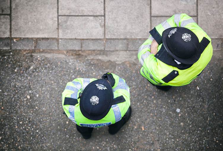 An image taken from above of two police officers stood outside on the street.