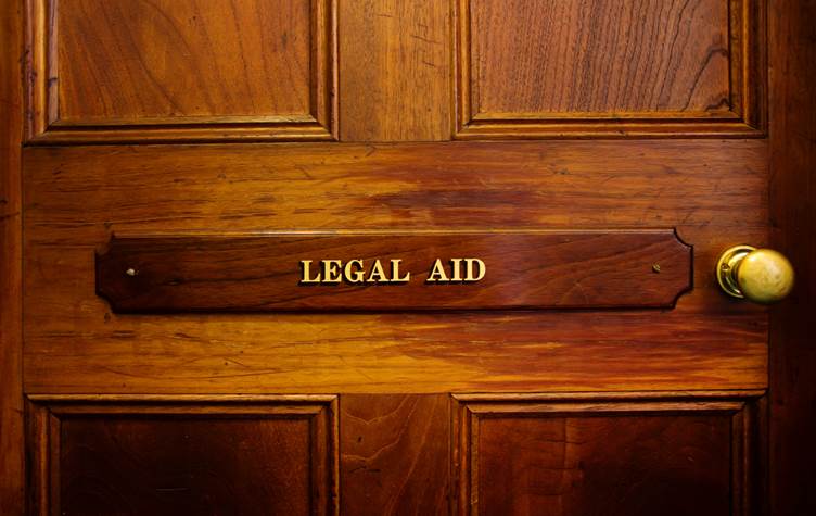 Picture of a wooden door with the words 'Legal aid' written on it in gold