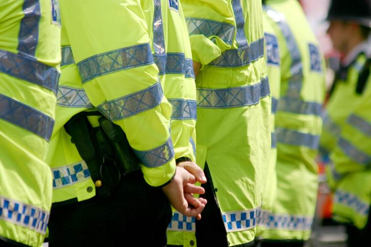 A picture of the back of a line of police officers stood side by side