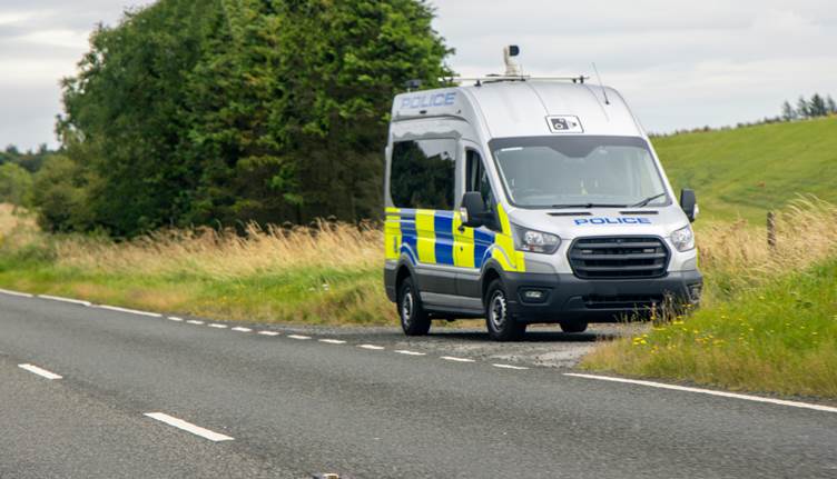 Picture of a police van parked on the side of a large road