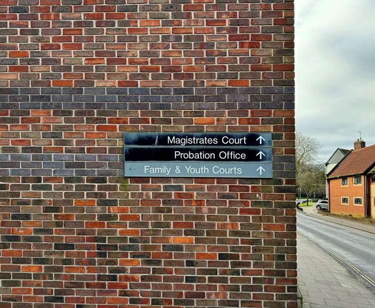 Information signs on a wall that show where the Magistrates Court, Probation Office and Family and Youth Courts are. 